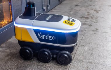 14 Aralık 2020, Moskova Rusya. Moskova 'daki bir restoranın girişindeki Yandex.Rover kafesinden yemek getiren insansız bir robot kurye..