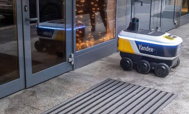 14 Aralık 2020, Moskova Rusya. Moskova 'daki bir restoranın girişindeki Yandex.Rover kafesinden yemek getiren insansız bir robot kurye..