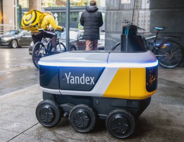 14 Aralık 2020, Moskova Rusya. Moskova 'daki bir restoranın girişindeki Yandex.Rover kafesinden yemek getiren insansız bir robot kurye..