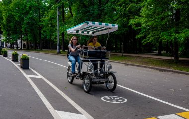 30 Mayıs 2019, Moskova, Rusya. Moskova 'daki Soklniki Park' ında iki kız triportöre biniyor..