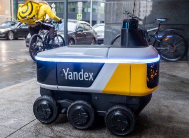 14 Aralık 2020, Moskova Rusya. Moskova 'daki bir restoranın girişindeki Yandex.Rover kafesinden yemek getiren insansız bir robot kurye..