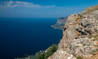 Akdeniz manzarası. Kırım Yarımadası 'nın güney kıyısındaki Karadeniz kıyısındaki orman kayaları güneşli bir günde.