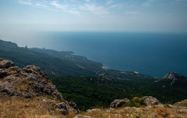 Akdeniz manzarası. Kırım Yarımadası 'nın güney kıyısındaki Karadeniz kıyısındaki orman kayaları güneşli bir günde.