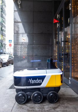 14 Aralık 2020, Moskova Rusya. Moskova 'daki bir restoranın girişindeki Yandex.Rover kafesinden yemek getiren insansız bir robot kurye..