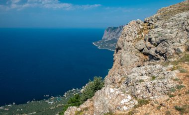 Akdeniz manzarası. Kırım Yarımadası 'nın güney kıyısındaki Karadeniz kıyısındaki orman kayaları güneşli bir günde.
