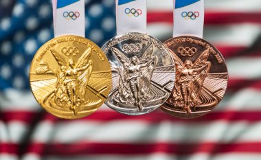25 Nisan 2021 Tokyo, Japonya. 2020 Tokyo Olimpiyat Oyunları 'nın altın, gümüş ve bronz madalyaları ABD bayrağının arka planında.