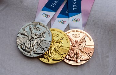17 Nisan 2021 Tokyo, Japonya. Tokyo 'da düzenlenen XXII Yaz Olimpiyat Oyunları' nın altın, gümüş ve bronz madalyaları sporcunun göğsünde.