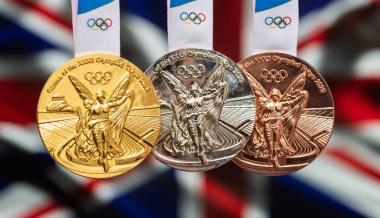 25 Nisan 2021 Tokyo, Japonya. Büyük Britanya bayrağının arka planında, 2020 Tokyo Olimpiyat Oyunları 'nın altın, gümüş ve bronz madalyaları yer alıyor..