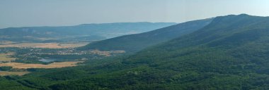 Akdeniz manzarası. Kırım Yarımadası 'nın güney kıyısındaki Karadeniz kıyısındaki orman kayaları güneşli bir günde.