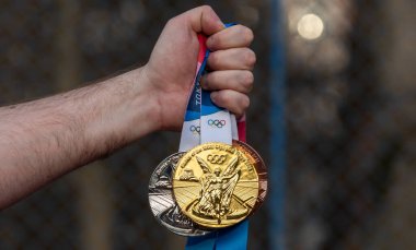 17 Nisan 2021 Tokyo, Japonya. Tokyo 'da düzenlenen XXII Yaz Olimpiyatları' nın altın, gümüş ve bronz madalyaları bir atletin elinde..