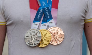 April 17, 2021 Tokyo, Japan. Gold, silver and bronze medals of the XXXII Summer Olympic Games in Tokyo on the chest of the athlete. clipart