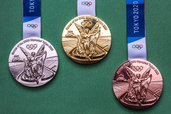 25 Nisan 2021 Tokyo, Japonya. Tokyo 'da düzenlenen XXII Yaz Olimpiyat Oyunları' nın altın, gümüş ve bronz madalyaları yeşil arka planda.