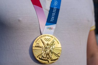 17 Nisan 2021 Tokyo, Japonya. Tokyo 'da düzenlenen XXXII Yaz Olimpiyat Oyunları' nın altın madalyası sporcunun göğsünde.