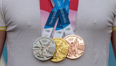 17 Nisan 2021 Tokyo, Japonya. Tokyo 'da düzenlenen XXII Yaz Olimpiyat Oyunları' nın altın, gümüş ve bronz madalyaları sporcunun göğsünde.