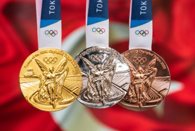 25 Nisan 2021 Tokyo, Japonya. Türkiye bayrağının arka planında, 2020 Tokyo Olimpiyat Oyunlarının altın, gümüş ve bronz madalyaları yer alıyor..
