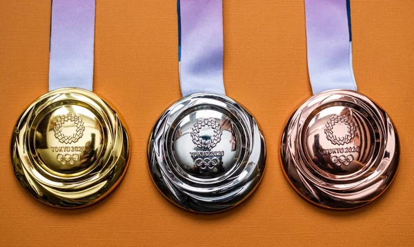 25 Nisan 2021 Tokyo, Japonya. Tokyo 'da düzenlenen 16. Dünya Yaz Olimpiyatları' nda altın, gümüş ve bronz madalyalar sarı arka planda..