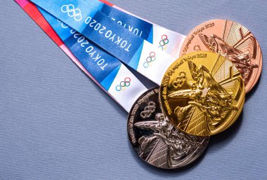 25 Nisan 2021 Tokyo, Japonya. Tokyo 'da düzenlenen XXII Yaz Olimpiyat Oyunlarının altın, gümüş ve bronz madalyaları koyu mavi arka planda.