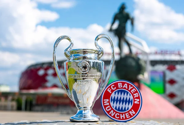 14 Haziran 2021 Münih, Almanya. FC Bayern Münih futbol kulübü ve UEFA Şampiyonlar Ligi Kupası 'nın amblemi modern bir stadyumun arka planına karşıdır..
