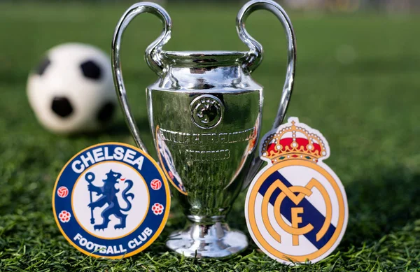16 Nisan 2021 Moskova, Rusya. UEFA Şampiyonlar Ligi Kupası ve çimlerin yeşil çimlerinde bulunan Real Madrid CF ve Chelsea F. C. London futbol kulüplerinin amblemleri..