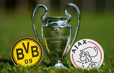 27 Ağustos 2021 Dortmund, Almanya. Futbol kulüpleri Borussia Dortmund ve AFC Ajax 'ın amblemleri ve stadyumun yeşil sahasındaki UEFA Şampiyonlar Ligi Kupası.