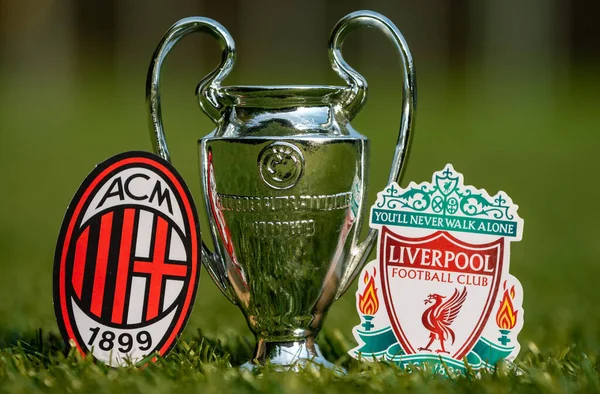 stock image August 27, 2021 Milan, Italy. Liverpool F.C. Football Club Emblems and A.C. Milan and the UEFA Champions League Cup on the green turf of the stadium.