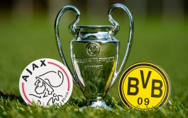27 Ağustos 2021 Amsterdam, Hollanda. Futbol kulüpleri Borussia Dortmund ve AFC Ajax 'ın amblemleri ve stadyumun yeşil sahasındaki UEFA Şampiyonlar Ligi Kupası.