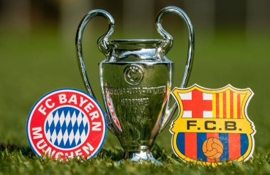 27 Ağustos 2021 Bavyera, Münih. Futbol kulüpleri FC Barcelona ve FC Bayern Münih 'in amblemleri ve stadyumun yeşil çimlerinde oynanan UEFA Şampiyonlar Ligi Kupası.