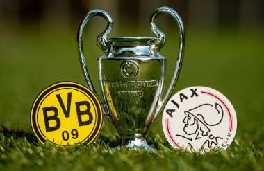 27 Ağustos 2021 Dortmund, Almanya. Futbol kulüpleri Borussia Dortmund ve AFC Ajax 'ın amblemleri ve stadyumun yeşil sahasındaki UEFA Şampiyonlar Ligi Kupası.