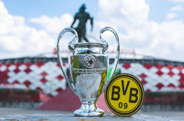 14 Haziran 2021 Dortmund, Almanya. Borussia Dortmund futbol kulübü ve UEFA Şampiyonlar Ligi Kupası 'nın amblemi modern bir stadyumun arka planına karşıdır..