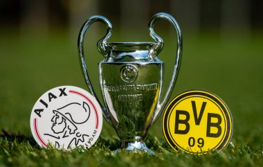 27 Ağustos 2021 Amsterdam, Hollanda. Futbol kulüpleri Borussia Dortmund ve AFC Ajax 'ın amblemleri ve stadyumun yeşil sahasındaki UEFA Şampiyonlar Ligi Kupası.