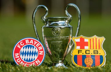 27 Ağustos 2021 Bavyera, Münih. Futbol kulüpleri FC Barcelona ve FC Bayern Münih 'in amblemleri ve stadyumun yeşil çimlerinde oynanan UEFA Şampiyonlar Ligi Kupası.