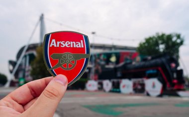 30 Ağustos 2021 Londra, İngiltere. Arsenal F.C. Modern bir stadyumun arka planına karşı futbol kulübü amblemi..