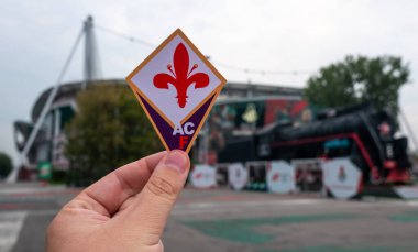 30 Ağustos 2021, Floransa, İtalya. Futbol kulübü ACF Fiorentina 'nın amblemi modern stadyumun arka planına karşıdır..