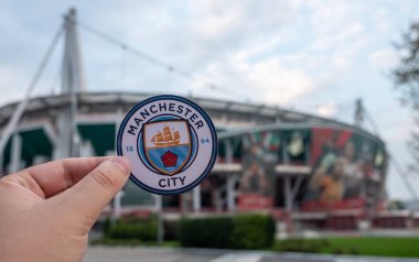 30 Ağustos 2021 Manchester, İngiltere. Manchester City 'den. Modern bir stadyumun arka planına karşı futbol kulübü amblemi..