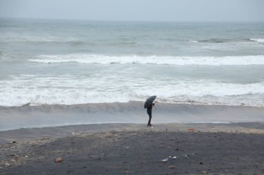 Şemsiyeli bir adam plajda