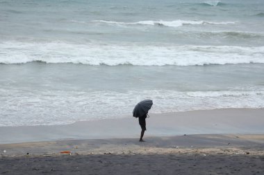 Şemsiyeli bir adam plajda