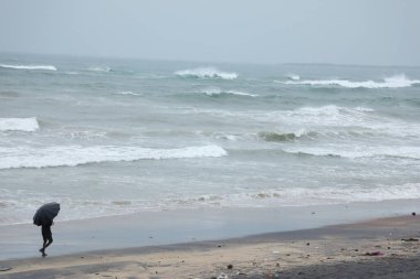 Şemsiyeli bir adam plajda