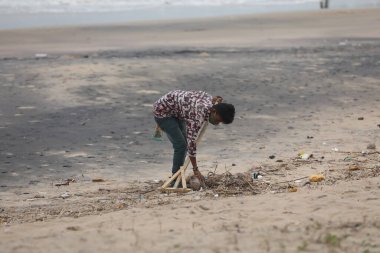 İşçiler sahile çöp atıyor.