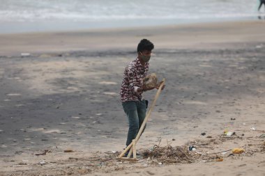 İşçiler sahile çöp atıyor.
