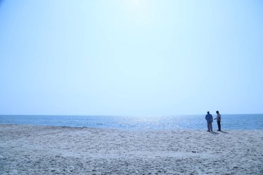 Sahilde bir balıkçının silueti.