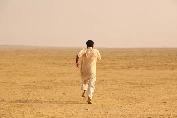 Mies juoksee aavikolla — kuvapankkivalokuva