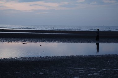 Vizag Hindistan sahilinde bir balıkçı silueti 1 Kasım 2025