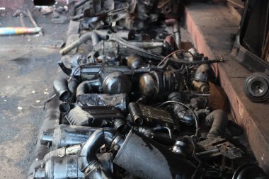 Tamirhanenin içinde düzgün ve gevşek bir şekilde düzenlenmiş yedek otomotiv parçaları koleksiyonu.