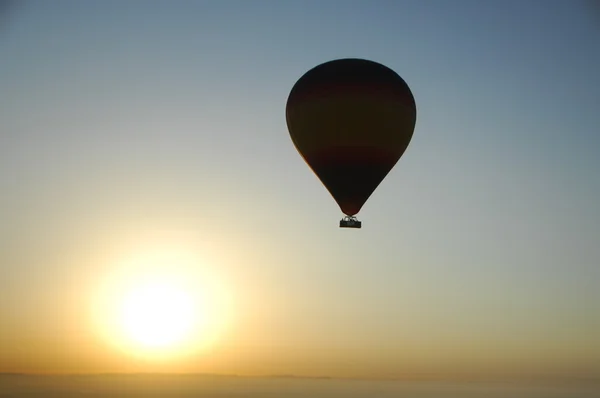 Balão de ar quente flutuando sobre a areia do deserto — Fotografia de Stock