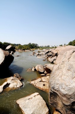 Su yosunlu kayaların arasından akıyor.