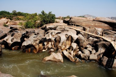 Su yosunlu kayaların arasından akıyor.