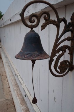 Bir ip ile duvardaki eski bronz çan