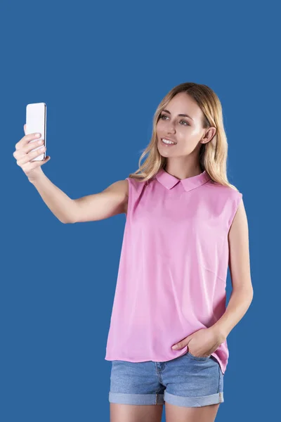 Blonde Girl Wearing Pink Blouse Jean Shorts Taking Selfie Stockfoto