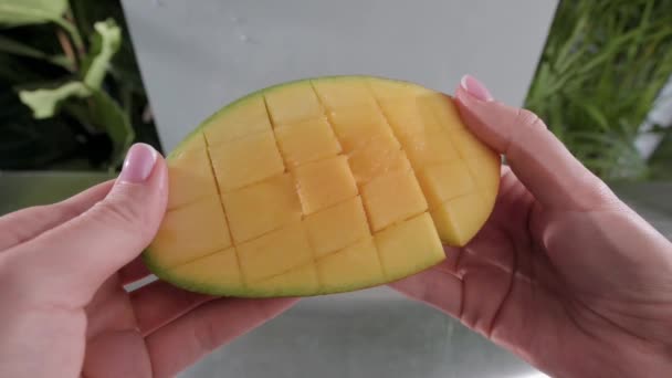 Женщина открывает вырезанный манго. Медленное движение. — стоковое видео