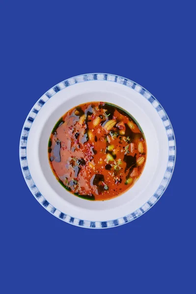 Gazpacho - Gemüsesuppe in schönem Teller isoliert auf blauem Hintergrund. Raum für Text. Foto für Menü und Website. Nahaufnahme. — Stockfoto